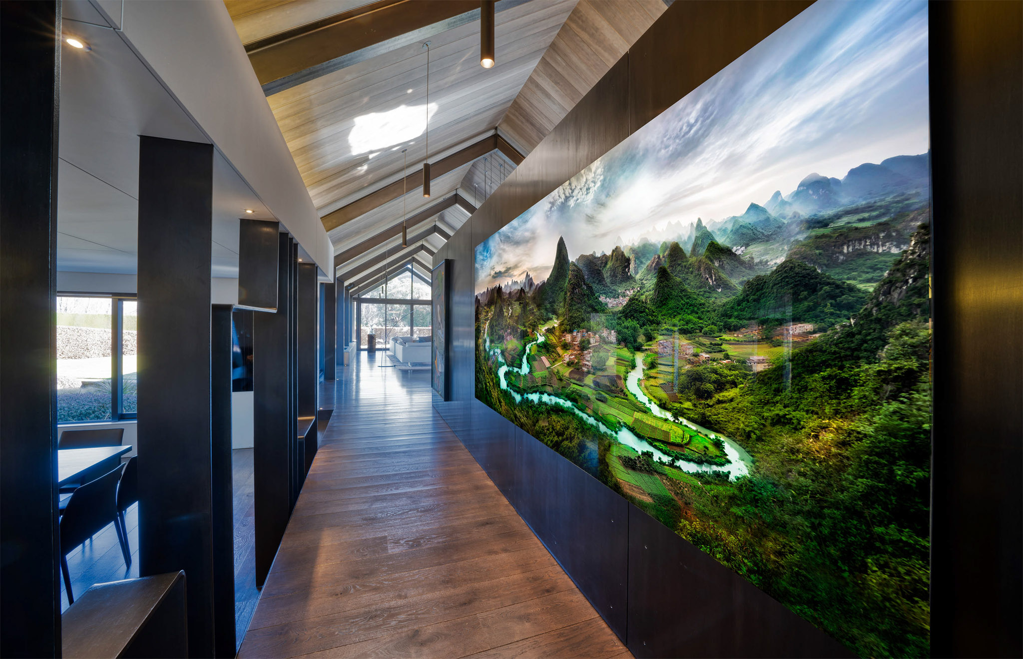 A large image of a Chinese landscape, 3meters long hung on the wall of a home of an art collector. The art is by Trey Ratcliff.